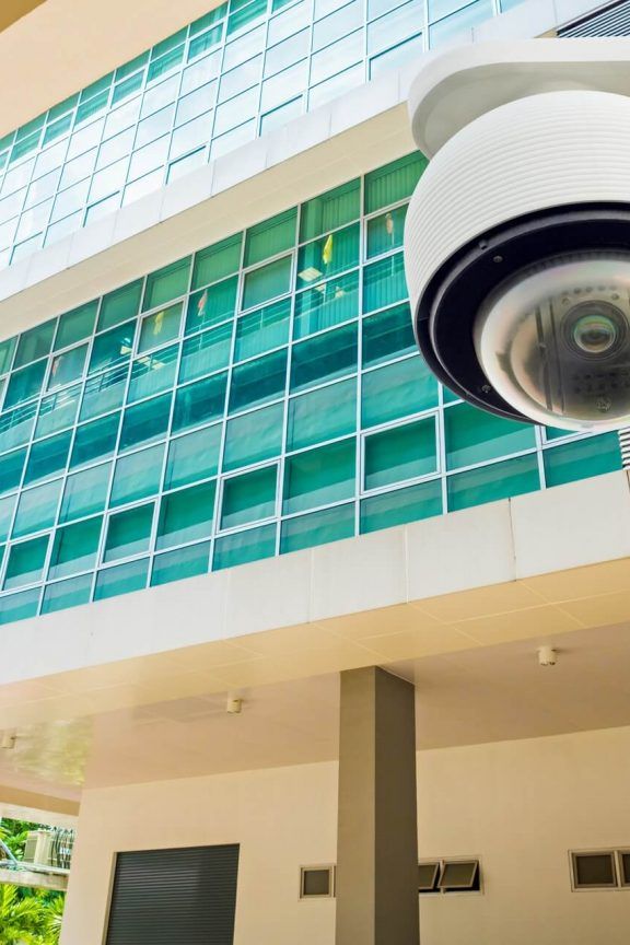 A white domed CCTV camera outside a building.