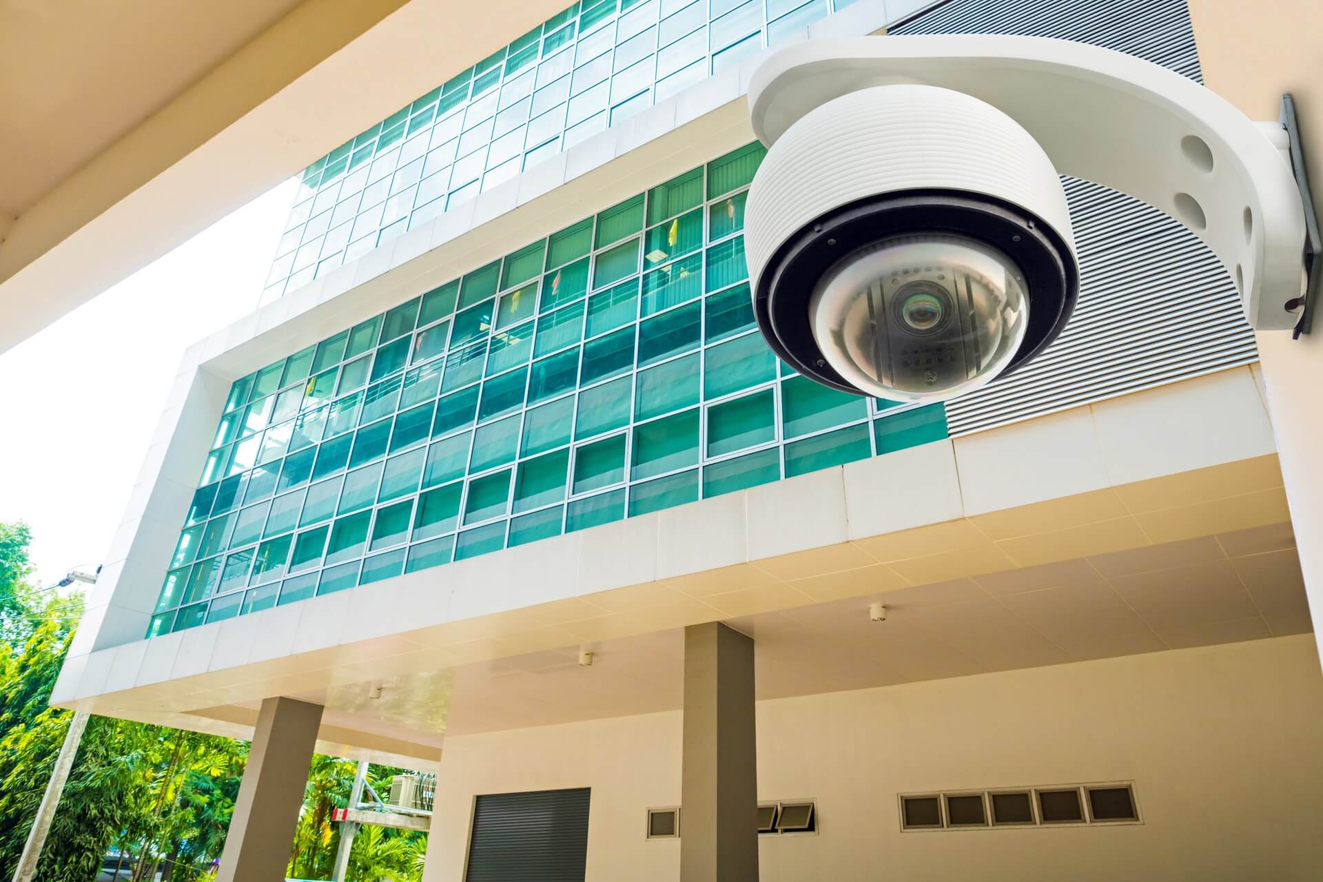 A white domed CCTV camera outside a building.