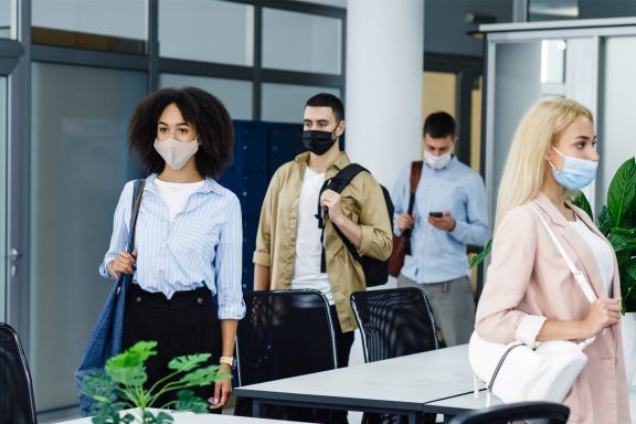 Office workers wearing face masks as part of COVID precautions.