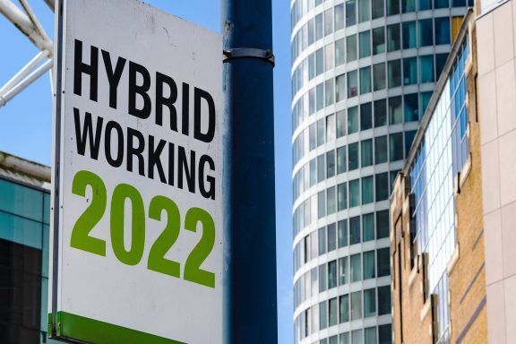A billboard outside a city building that reads 'Hybrid Working 2022'.