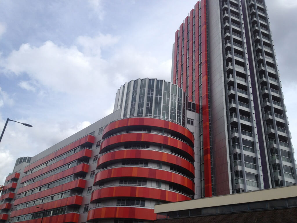 A modern block of flats with red cladding.