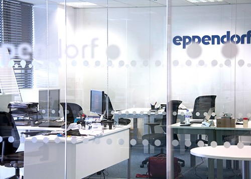 Looking through a glass wall into a communal office.